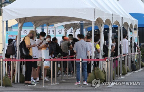 4일 오전 서울 중구 서울역 광장에 설치된 코로나19 임시 선별검사소에서 시민들이 검사를 기다리고 있다.   연합뉴스
